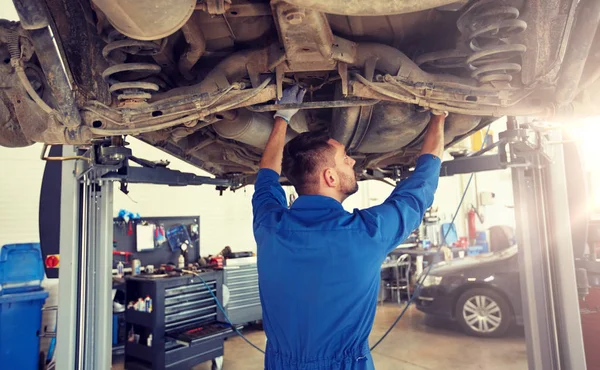 Механічний чоловік або коваль ремонтує автомобіль на майстерні — стокове фото