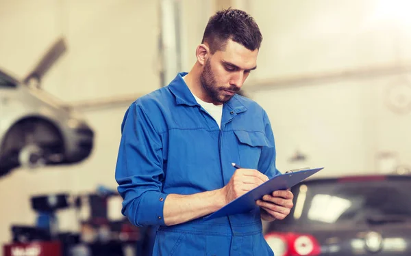 Meccanico auto uomo con appunti presso officina auto — Foto Stock