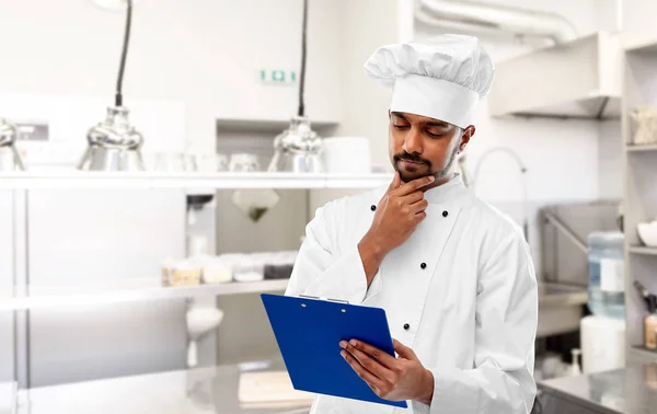 Indischer Koch mit Klemmbrett in der Restaurantküche — Stockfoto