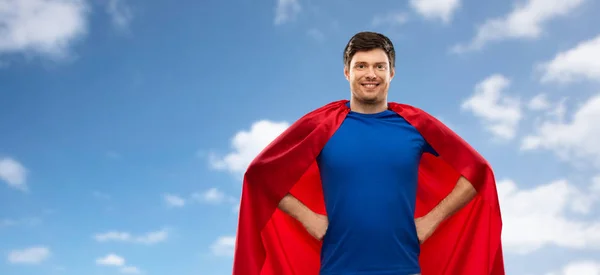 Man in red superhero cape over sky background — Stock Photo, Image