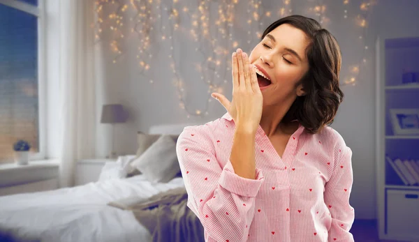 Feliz joven soñolienta mujer en pijama bostezando — Foto de Stock