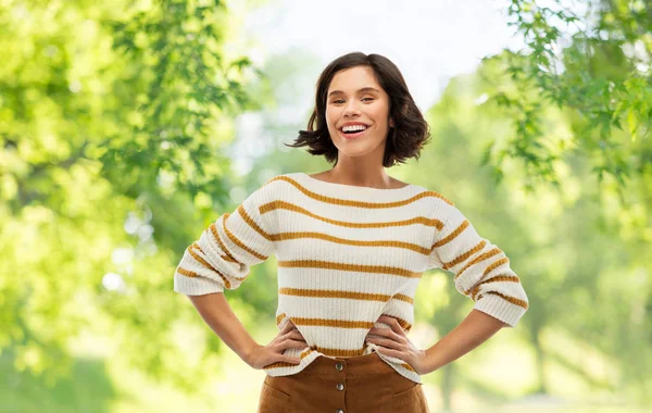 Femme souriante en pull avec les mains sur les hanches — Photo