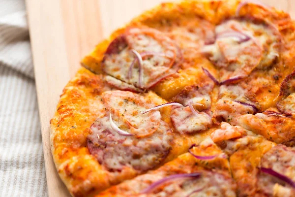 Close-up de pizza caseira na mesa de madeira — Fotografia de Stock