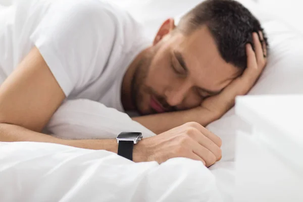 Primo piano di uomo con orologio intelligente dormire a letto — Foto Stock