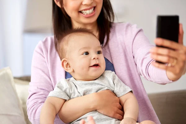 Asiática mãe com bebê filho tomando selfie em casa — Fotografia de Stock