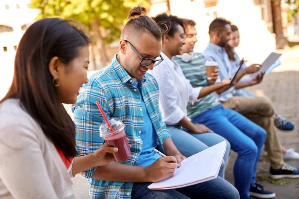 Gruppe glücklicher Schüler mit Notizbuch und Getränken — Stockfoto