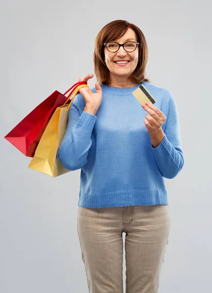 Mulher sênior com sacos de compras e cartão de crédito — Fotografia de Stock