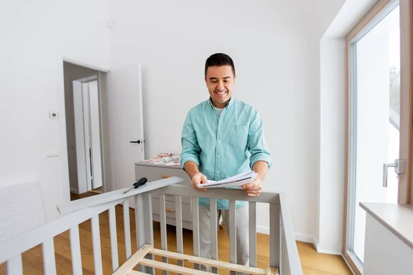 Père avec montage manuel lit bébé à la maison — Photo