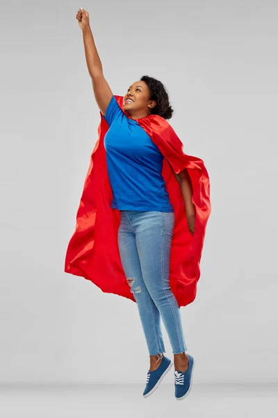 Mulher afro-americana em capa de super-herói voando para cima — Fotografia de Stock