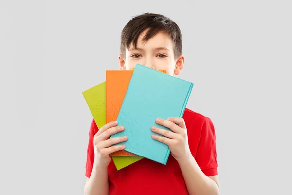 Tímido colegial escondido detrás de libros —  Fotos de Stock