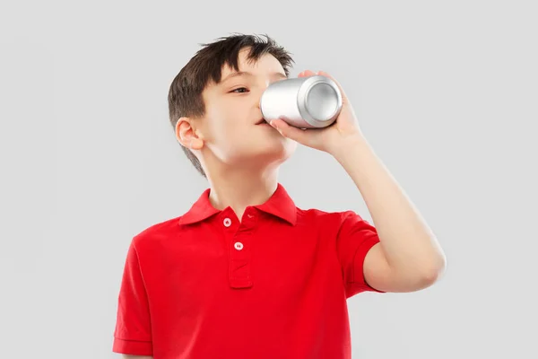 Garçon en t-shirt rouge boire soda de boîte de conserve — Photo