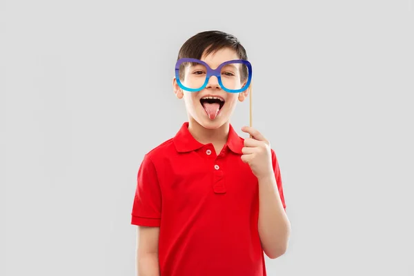 Ευτυχισμένο αγόρι με μεγάλα ποτήρια χαρτί που δείχνουν τη γλώσσα — Φωτογραφία Αρχείου