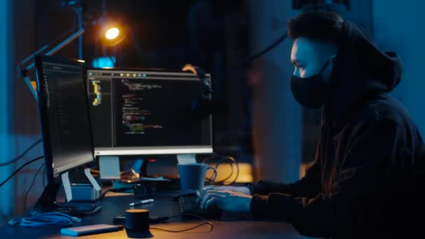 Hacker in Maske nutzt Computer für Cyber-Angriff — Stockvideo