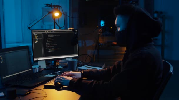 Хакер, использующий компьютер для кибератаки ночью — стоковое видео