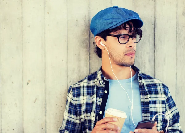 Hombre con auriculares y teléfono inteligente beber café —  Fotos de Stock