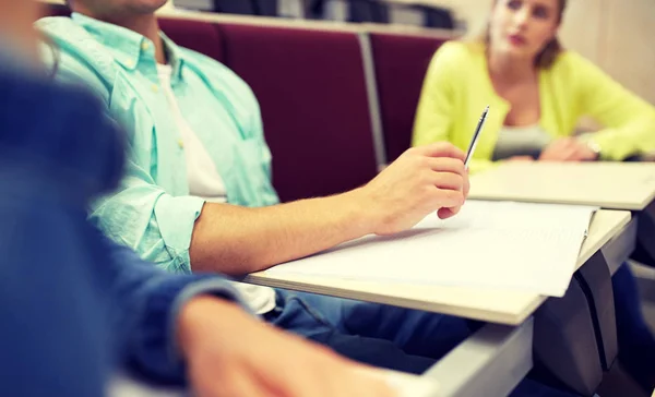 Grupo de estudiantes con cuadernos en la sala de conferencias — Foto de Stock