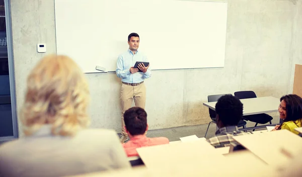 Studenci i nauczyciel z tabletem na wykładzie — Zdjęcie stockowe