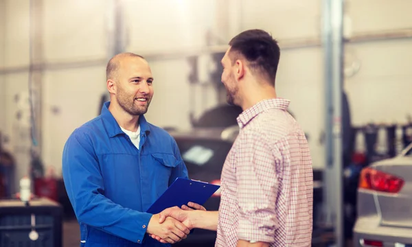 Mécanicien automobile et homme serrant la main à l'atelier de voiture — Photo