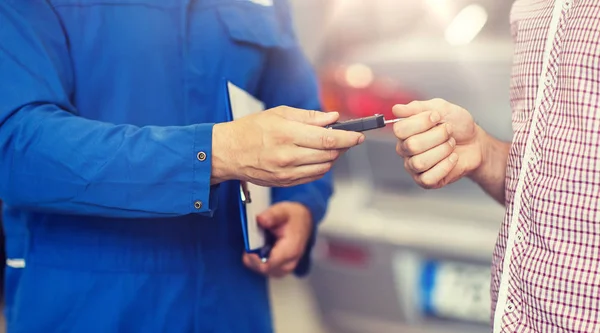 Bilmekaniker som ger bilnyckel till mannen på verkstad — Stockfoto