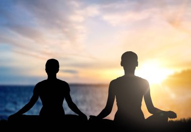 couple doing yoga in lotus pose over sea sunset clipart