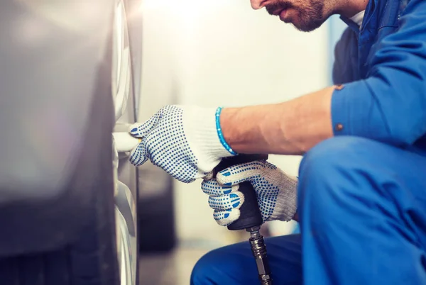 Meccanico con cacciavite cambio gomme auto — Foto Stock