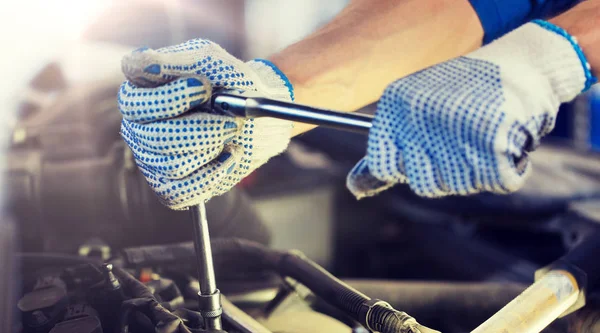 Mechanik człowiek z kluczem naprawy samochodu w warsztacie — Zdjęcie stockowe