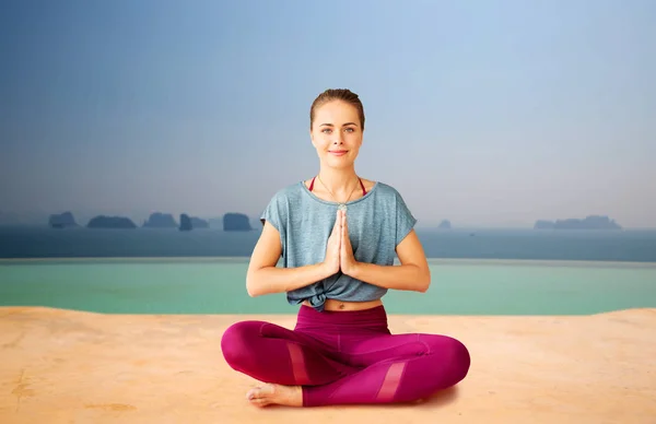 Mujer haciendo yoga y meditando en pose de loto —  Fotos de Stock