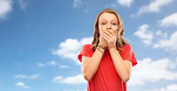 Shocked teenage girl covering her mouth over sky — Stock Photo, Image