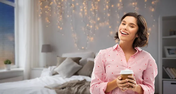 Lycklig ung kvinna i pyjamas med kopp kaffe — Stockfoto
