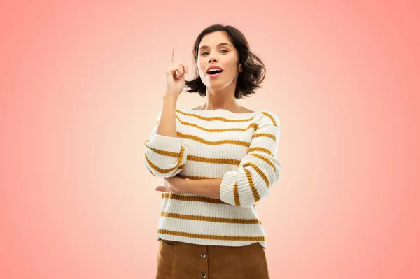 Kobieta w pasiastej swetrze wskazując jej palec w górę — Zdjęcie stockowe