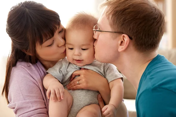 快乐的母亲和父亲在家里亲吻小儿子 — 图库照片