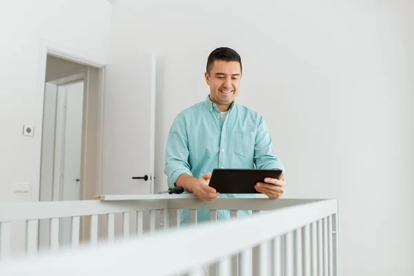 Père avec tablette pc assembler lit bébé à la maison — Photo