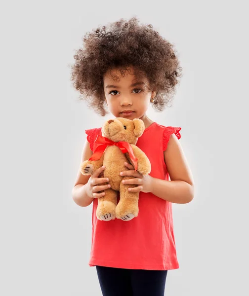 Сумна маленька афроамериканська дівчинка з плюшевим ведмедем — стокове фото