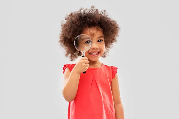 African girl looking through magnifying glass — Stock Photo, Image