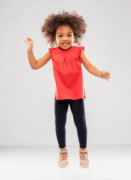 Щаслива маленька афроамериканська дівчинка стрибає — стокове фото