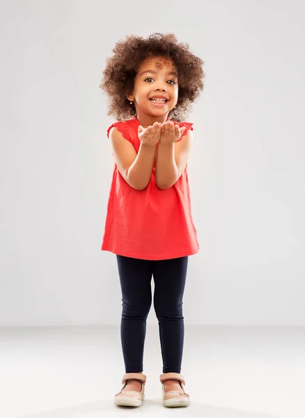 Happy african american girl holding something — Stock Photo, Image