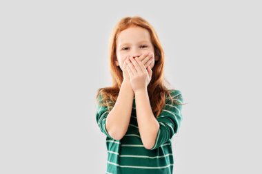 confused red haired girl covering mouth by hands clipart