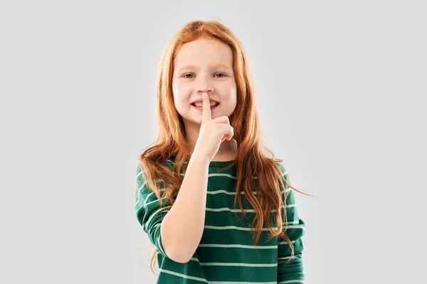 Leende rödhåriga flicka som gör Shush gest — Stockfoto
