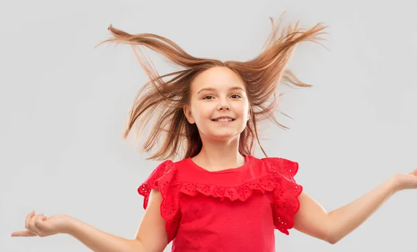 머리를 흔드는 빨간 셔츠에 행복한 소녀 — 스톡 사진
