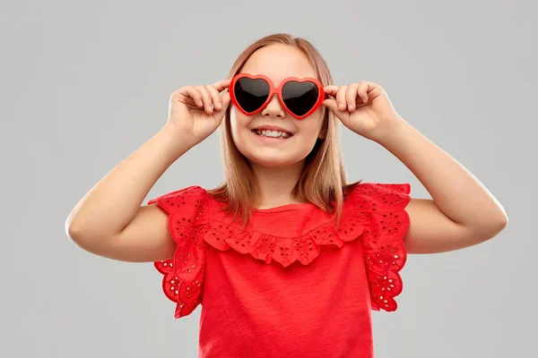 Niña preadolescente sonriente con gafas de sol en forma de corazón — Foto de Stock