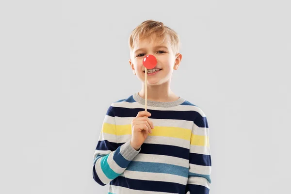 Sorrindo menino com vermelho palhaço nariz festa adereço — Fotografia de Stock
