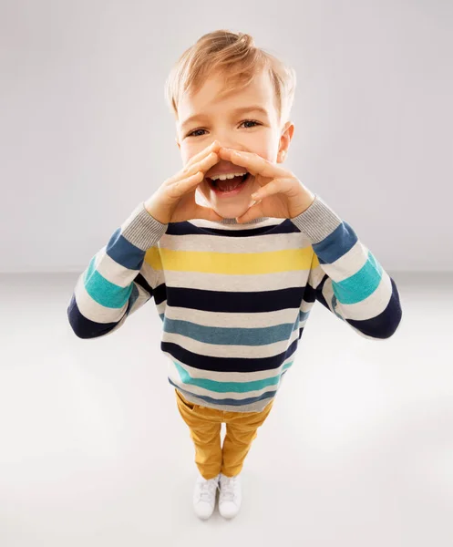 Mały chłopiec w pasiasty sweter dzwoniąc do kogoś — Zdjęcie stockowe