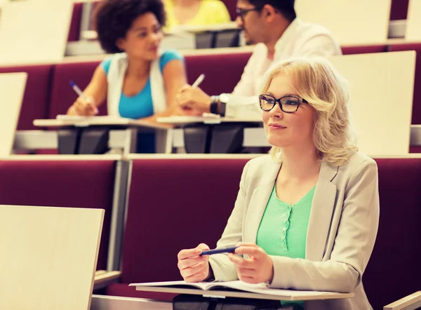 Estudiante escribiendo a cuaderno en sala de conferencias —  Fotos de Stock