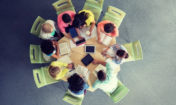 Gruppo di studenti con tablet pc presso la biblioteca scolastica — Foto Stock