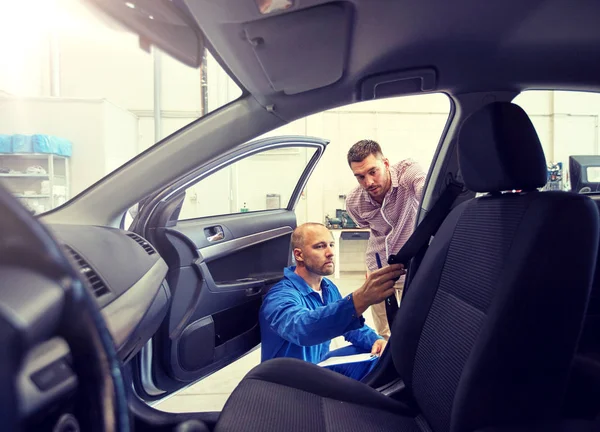 メカニックと男の車屋でシートベルトをチェック — ストック写真