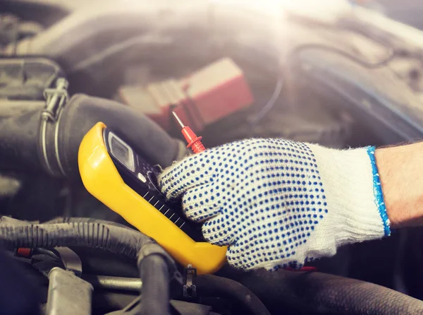 Auto mekaniker man med multimeter testa batteriet — Stockfoto