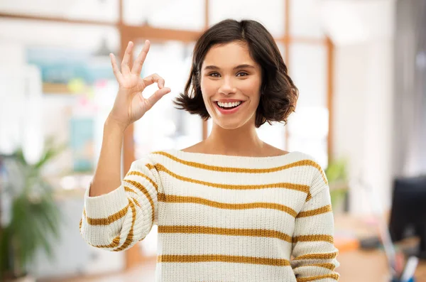 Feliz sorrindo mulher em pulôver listrado mostrando ok — Fotografia de Stock