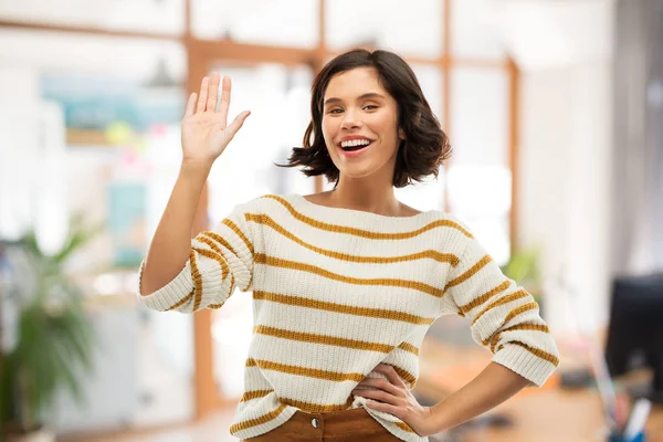 Mujer sonriente en jersey a rayas agitando la mano — Foto de Stock