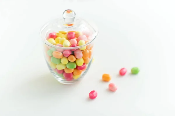 Glass jar with candy drops over white background — Stock Photo, Image
