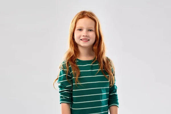 Usmívající se zrzavá dívka v proužkované košili — Stock fotografie